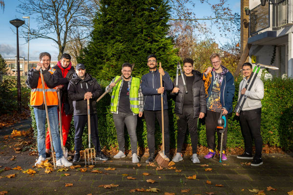 Waalhandjes staan op een rij met tuingereedschap in hun handen