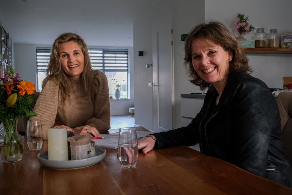 Twee vrouwen zitten samen aan tafel