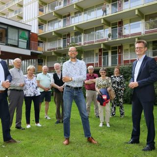 Groep met mensen staan voor een woongebouw
