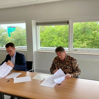 Twee mannen ondertekenen papieren