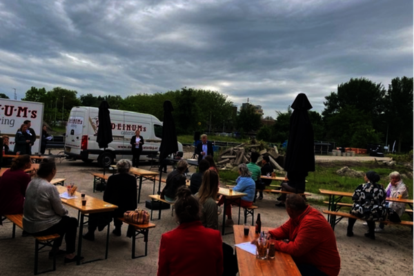 Mensen zitten aan picnictafels