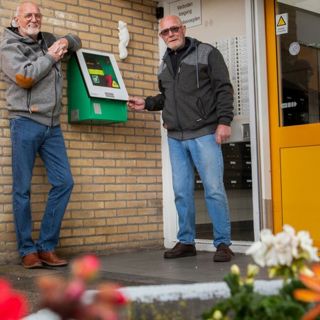 Twee mannen staan bij een aed-apparaat
