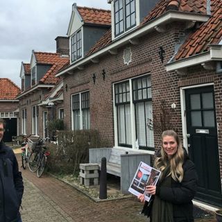 Twee medewerkers van Intermaris staan met het werken aan wonen boekje in de wijk