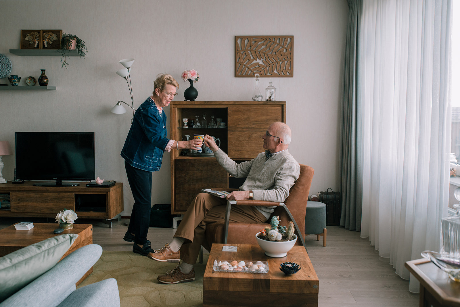 Bewoner geeft kopje koffie aan haar man