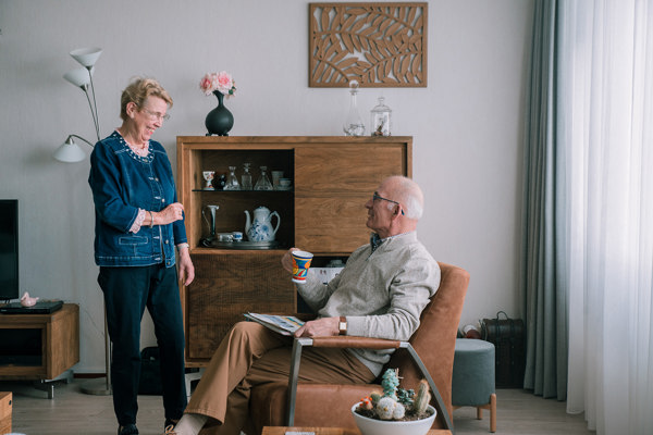 Bewoner geeft een kopje koffie aan haar man 