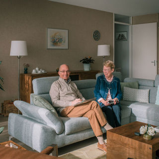 Ouder stel zit samen op de bank