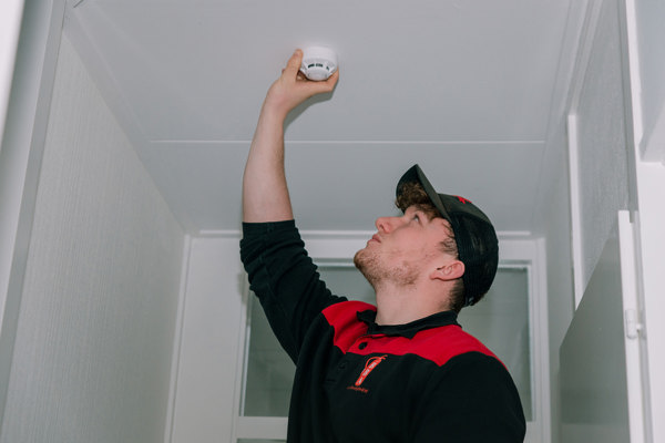 Man hangt een rookmelder op