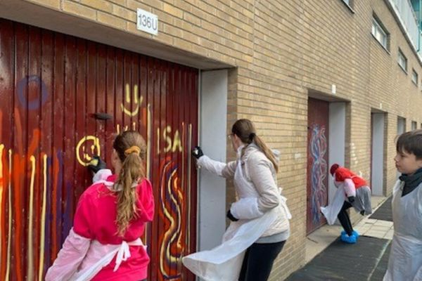 Jongeren sprayen graffiti op een garagedeur