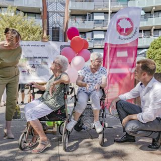 Directeur Cees Tip praat met oudere vrouw met een rollator