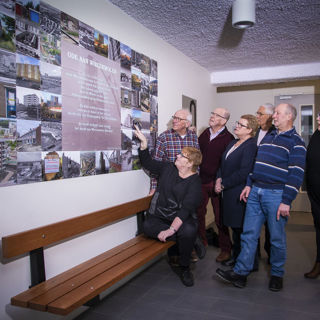 Bewoners kijken naar fotocollage aan de muur