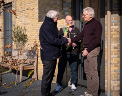 Bewoner ontvangt een bos tulpen van de directeur tijdens complimentendag