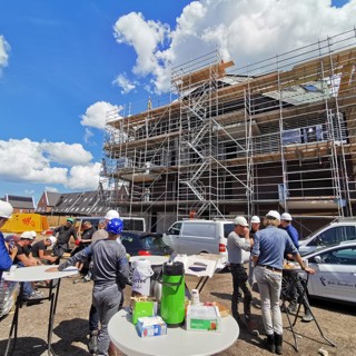 Woongebouw staat in de steigers, voor het gebouw staan bouwvakkers en medewerkers van Intermaris