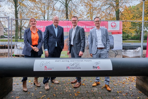 Directeuren en wethouders staan bij leidingenbuis voor start Warmtenet