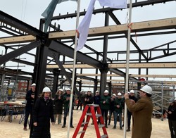 De vlag van Intermaris wordt gehesen bij een nieuwbouw project