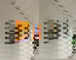 Drie kleurrijke schilderijen aan de muur 