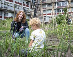 Medewerker Intermaris poseert in moestuin Grote Waal