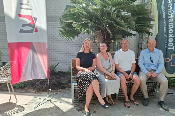 Vier mensen zitten op een bankje
