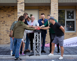 Bewoners, wethouder Dick Bennis en directeur-bestuurder Cees Tip, Intermaris drukken op knop voor confetti