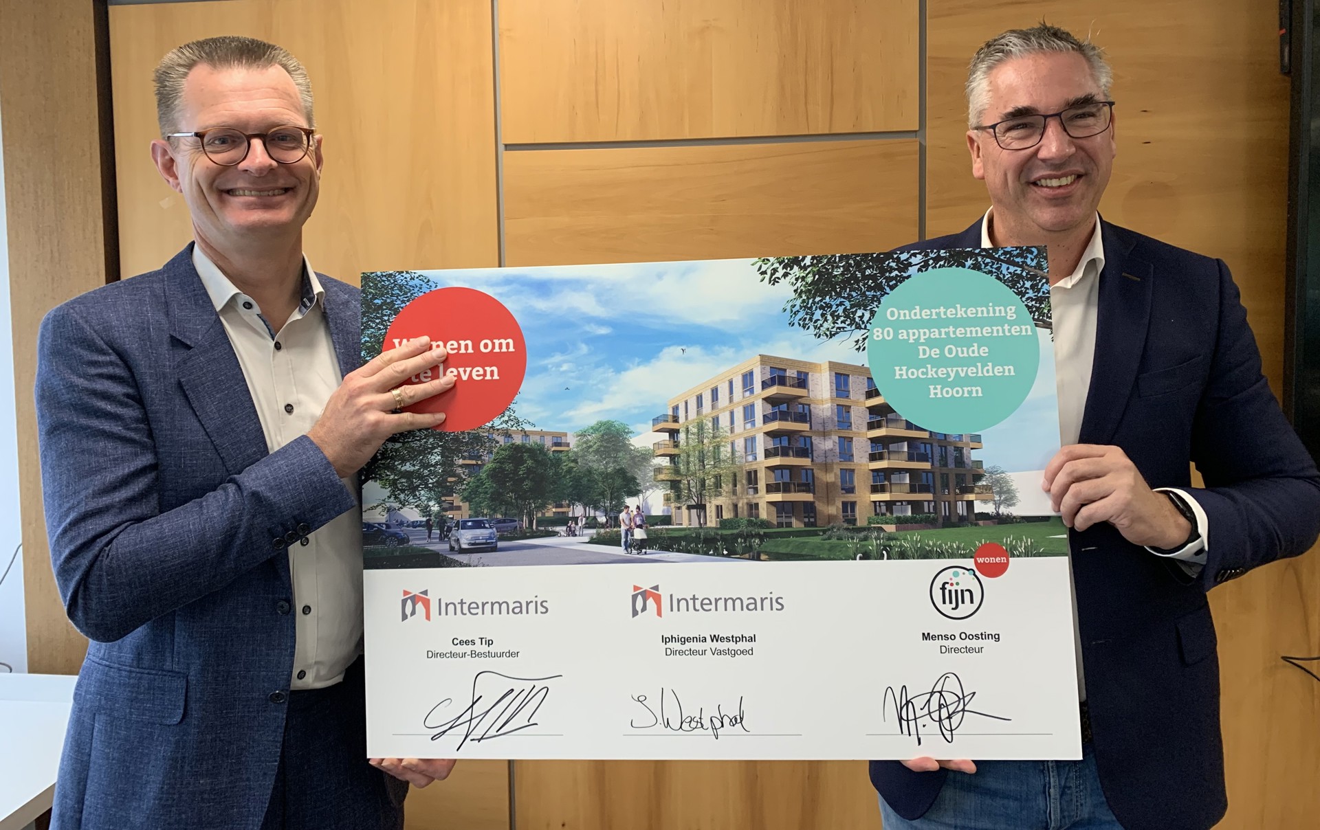 Directeur Fijn Wonen, Menso Oosting en directeur-bestuurder Intermaris, Cees Tip houden bord omhoog met handtekeningen De Oude Hockeyvelden