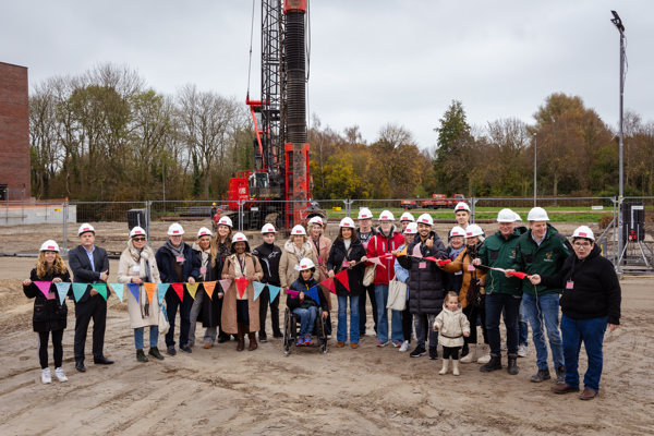 Genodigden en toekomstige bewoners houden vlaggenlijn vast op bouwlocatie Blok 14