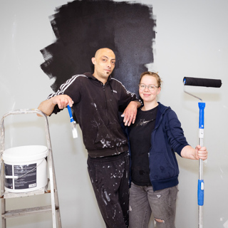 Stel schildert een muur zwart