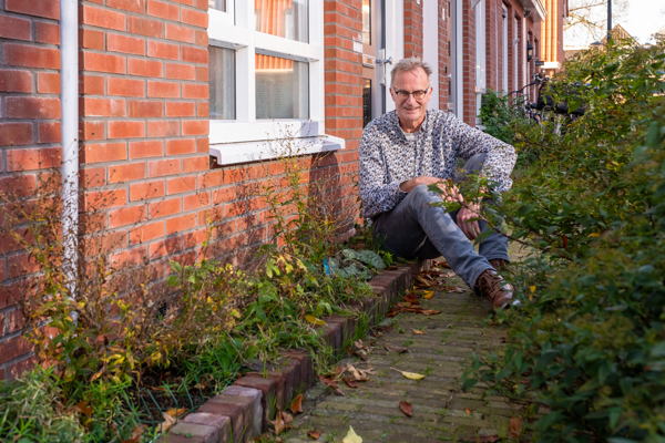 Bewoner Jos zit voor zijn geveltuintje