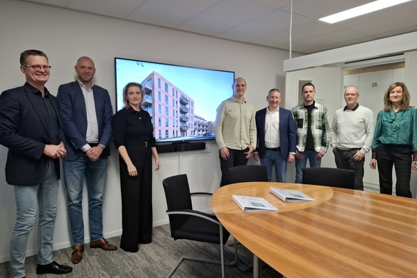 Acht medewerkers van Intermaris en Hoog Over staan voor televisiescherm impressie Henri Dunantstraat