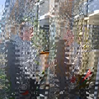 Wijkconsulent deelt tulpen uit aan huurder