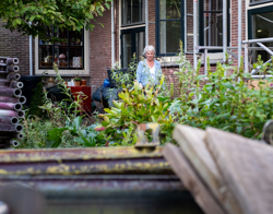 Bewoonster loopt door de binnentuin van het woongebouw langs steigers die tegen het woongebouw aanstaan.