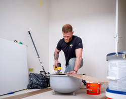 Bewoner zaagt een vloerplank op maat in zijn woning 