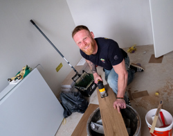 Bewoner zaagt een vloerplank op maat in zijn woning 