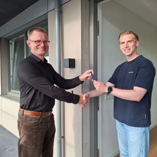 Directeur Cees Tip overhandigt sleutels aan een bewoner