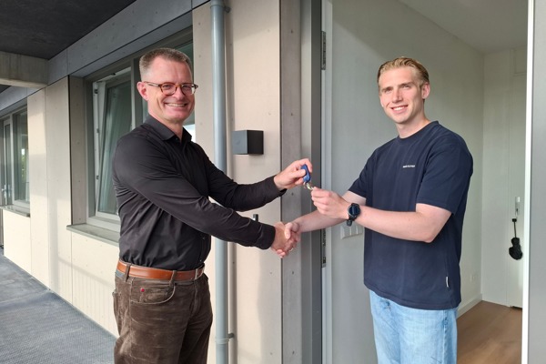 Directeur Cees Tip overhandigt sleutels aan een bewoner